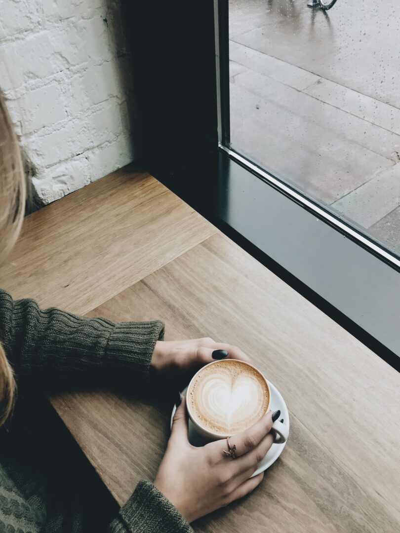 Κοπέλα κρατάει καφέ 