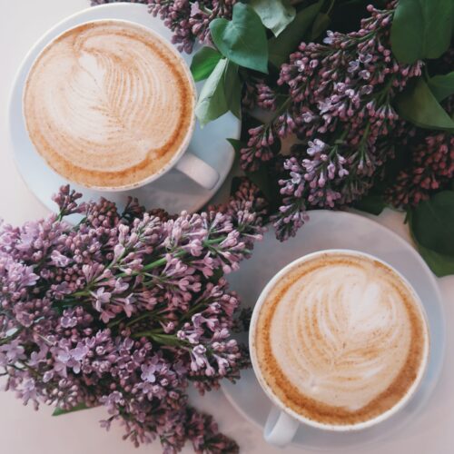 δυο φλυτζανια με καφε και μωβ λουλουδια