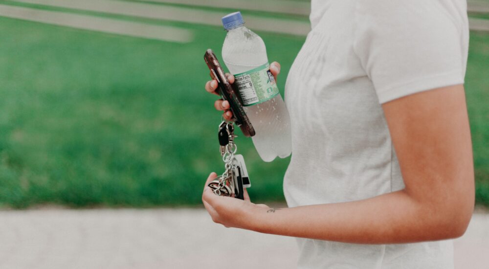 γυναικα που περπαταει και κραταει μπουκαλι με νερο