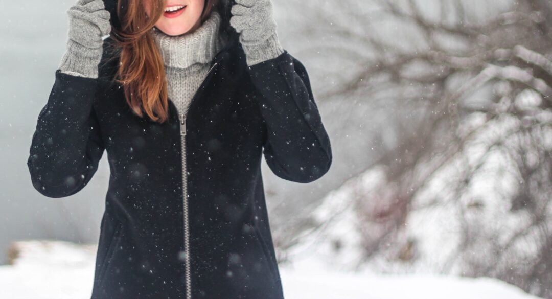 γυναικα μέσα σε χιονισμενο τοπίο με μαυρο μπουφαν 