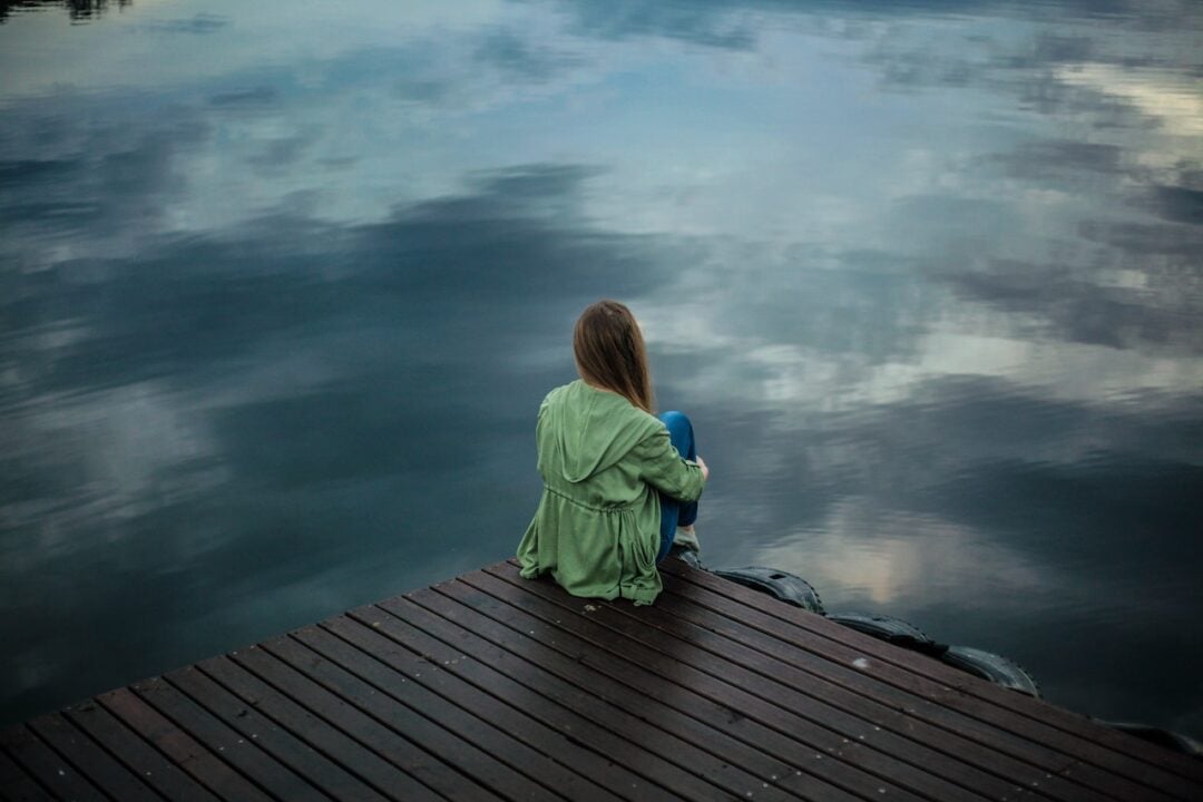 κοπέλα κάθεται σε λίμνη