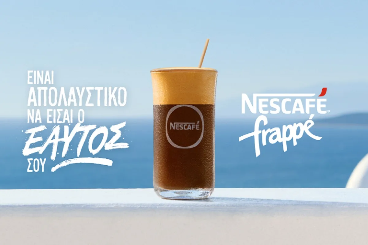 Φωτογραφία με ποτήρι Nescafé Frappé σε καλοκαιρινό φόντο με θέα τη θάλασσα